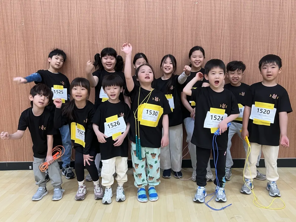 참가 번호표를 달고 줄넘기를 든 채 웃는 아이들